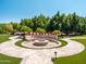 Stunning backyard fire pit area with circular travertine patio, and lush landscaping; great for entertaining at 5040 N Arcadia Dr, Phoenix, AZ 85018