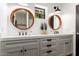 Elegant bathroom featuring dual sinks with wood framed mirrors and sleek fixtures complemented by white countertops at 5040 N Arcadia Dr, Phoenix, AZ 85018