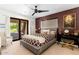 Comfortable bedroom with a patterned bedspread, desk area, and sliding door to the beautifully landscaped backyard at 5040 N Arcadia Dr, Phoenix, AZ 85018