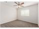 This carpeted bedroom features a ceiling fan and a window with blinds at 5233 W Albeniz Pl, Phoenix, AZ 85043