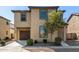View of a two-story tan home with a brown garage door and desert landscaping at 5233 W Albeniz Pl, Phoenix, AZ 85043