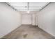 A two-car garage with white walls, gray floor, and a door leading to the house at 5233 W Albeniz Pl, Phoenix, AZ 85043