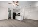 A spacious living room features gray carpet and mixed flooring, with an adjacent open kitchen and modern ceiling fan at 5233 W Albeniz Pl, Phoenix, AZ 85043