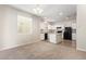 Open concept with plush carpet and white kitchen with modern island and black appliances at 5472 W Fulton St, Phoenix, AZ 85043