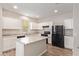 Bright kitchen features white cabinetry, gray countertops, and a black refrigerator at 5472 W Fulton St, Phoenix, AZ 85043