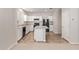 Modern kitchen with white cabinets, a central island, black appliances and wood-look flooring at 5472 W Fulton St, Phoenix, AZ 85043