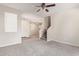 Open living area featuring plush carpet, large windows, and a view of the staircase and entry at 5472 W Fulton St, Phoenix, AZ 85043
