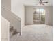 Neutral living room featuring a staircase, plush carpeting, and a sliding glass door to the backyard at 5472 W Fulton St, Phoenix, AZ 85043
