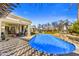 Beautiful backyard featuring a pool with a waterfall, a covered dining area, and lush landscaping at 5670 W Linda Ln, Chandler, AZ 85226