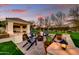 Backyard oasis featuring a fire pit, lounge chairs, lush landscaping, and covered patio at 5670 W Linda Ln, Chandler, AZ 85226