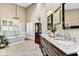 Elegant bathroom featuring a soaking tub, marble countertops, and a decorative chandelier for a luxurious feel at 5670 W Linda Ln, Chandler, AZ 85226