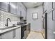 Well-organized laundry room with gray cabinets, modern appliances, and a functional sink area at 5670 W Linda Ln, Chandler, AZ 85226