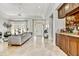 Bright and open living room with travertine floors, a wet bar, and French doors to an outdoor space at 5670 W Linda Ln, Chandler, AZ 85226