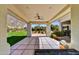 Spacious covered patio with a ceiling fan, stone columns, and an expansive view of the green backyard at 5670 W Linda Ln, Chandler, AZ 85226