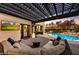 Relaxing patio area with sectional seating, outdoor television, and a view of the pool and landscaped backyard at 5670 W Linda Ln, Chandler, AZ 85226