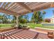 Charming covered patio features a pergola, brick flooring, and views of lush landscaping and the golf course at 5801 N 25Th Pl, Phoenix, AZ 85016
