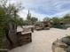 Expansive backyard showcasing an outdoor kitchen, fireplace, pool, and desert landscaping against a clear blue sky at 6181 E Brilliant Sky Dr, Scottsdale, AZ 85266