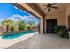 Covered outdoor patio area overlooking a pool, featuring elegant stone flooring and a seamless blend of indoor-outdoor living at 6181 E Brilliant Sky Dr, Scottsdale, AZ 85266