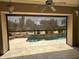 Covered patio space with a retractable screen, offering views of a pool and desert landscape for year-round enjoyment at 6181 E Brilliant Sky Dr, Scottsdale, AZ 85266