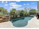 Beautiful backyard pool surrounded by mature landscaping, stone accents, and a serene water feature on a sunny day at 6181 E Brilliant Sky Dr, Scottsdale, AZ 85266