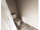 Cozy powder room features modern toilet, neutral paint, and wood-look tile flooring at 8315 W Concordia Dr, Arizona City, AZ 85123