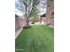 A well manicured backyard featuring artificial grass, desert landscaping, and a built in fire pit at 8339 W Molly Ln, Peoria, AZ 85383