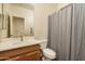 Bright bathroom featuring vanity sink, toilet, and shower with curtain at 8339 W Molly Ln, Peoria, AZ 85383