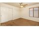 Bedroom with carpet, sliding-door closet, window with blinds, and ceiling fan at 8339 W Molly Ln, Peoria, AZ 85383