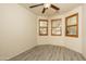 Bright bedroom featuring wood-look floors, ceiling fan, and multiple windows at 8339 W Molly Ln, Peoria, AZ 85383