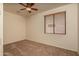 Carpeted bedroom featuring a ceiling fan and standard window with blinds at 8339 W Molly Ln, Peoria, AZ 85383