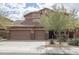 Front exterior of a home featuring a three-car garage, desert landscaping and a well-maintained lawn at 8339 W Molly Ln, Peoria, AZ 85383