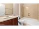 This traditional bathroom has a wooden vanity, toilet, shower and bath combo, and updated fixtures at 8367 W Lariat Ln, Peoria, AZ 85383