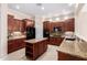 Well-equipped kitchen with granite countertops, dark wood cabinets, and modern appliances at 8367 W Lariat Ln, Peoria, AZ 85383