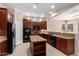 Well-lit kitchen with dark wood cabinetry, stainless steel appliances, and a center island at 8367 W Lariat Ln, Peoria, AZ 85383