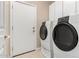 Bright laundry room features modern washer and dryer, tile floors, and white cabinets at 8367 W Lariat Ln, Peoria, AZ 85383