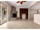 Spacious living area with a stone fireplace, built-in shelving, and access to the outdoor pool at 8367 W Lariat Ln, Peoria, AZ 85383