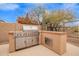 Outdoor kitchen features stainless steel grill, storage, and natural stone countertop at 8367 W Lariat Ln, Peoria, AZ 85383