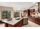 This spacious kitchen features custom cabinets, granite countertops, stainless steel appliances, and island with breakfast bar at 8861 E Sutton Dr, Scottsdale, AZ 85260