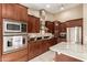 The kitchen has a stainless steel oven, stainless vent hood, and custom cabinets at 8861 E Sutton Dr, Scottsdale, AZ 85260