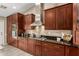 A full view of the custom cabinets, stone backsplash, and stainless vent hood in the kitchen at 8861 E Sutton Dr, Scottsdale, AZ 85260