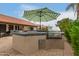 Outdoor kitchen area featuring a stainless steel grill and green and white umbrella at 8861 E Sutton Dr, Scottsdale, AZ 85260