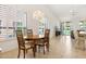 Dining area featuring a chandelier, bright light, and view of the back patio through shutters at 9608 E Nacoma Dr, Sun Lakes, AZ 85248
