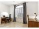 A home office with natural light from a large window and neutral tile flooring at 9608 E Nacoma Dr, Sun Lakes, AZ 85248