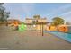 Backyard featuring a sparkling pool, covered patio, and privacy walls with unique art at 9834 N 1St St, Phoenix, AZ 85020