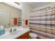 Bright bathroom with wood vanity and a shower with a patterned curtain at 995 E Vernoa St, San Tan Valley, AZ 85140