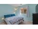 A tranquil bedroom with blue walls, plush bedding, and a large window at 995 E Vernoa St, San Tan Valley, AZ 85140