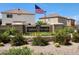 Attractive entrance to Cambria Ocotillo featuring stone accents, lush landscaping, and the American flag at 995 E Vernoa St, San Tan Valley, AZ 85140