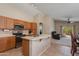 Bright open kitchen with oak cabinets, tile flooring, and a peninsula countertop at 995 E Vernoa St, San Tan Valley, AZ 85140