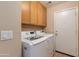 Laundry room with white washer and dryer and natural wood cabinets at 995 E Vernoa St, San Tan Valley, AZ 85140