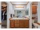Well-lit bathroom featuring a vanity with wood cabinets and a walk-in closet at 995 E Vernoa St, San Tan Valley, AZ 85140